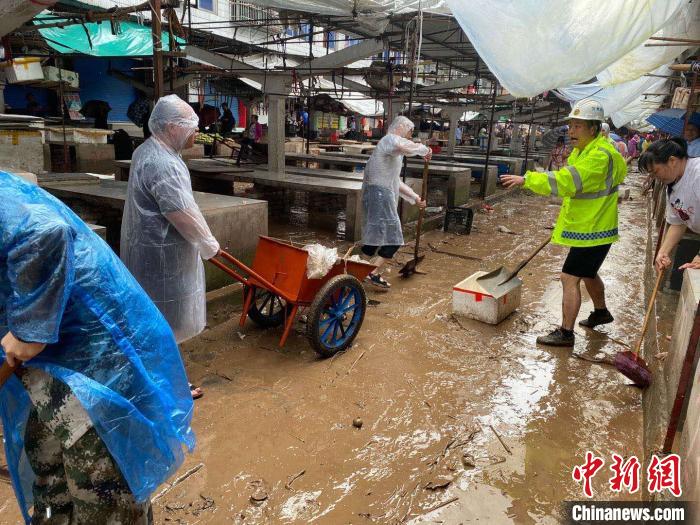 圖為7月26日，暴雨引發(fā)的洪水過境后，重慶萬州區(qū)分水鎮(zhèn)政府干部職工及志愿者清掃淤泥和垃圾?！　≈貞c萬州區(qū)委宣傳部供圖 攝