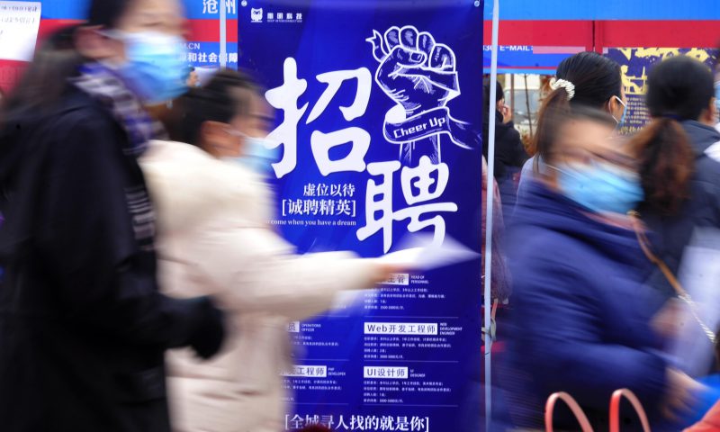 求職者從一家招聘企業(yè)的廣告牌前走過(guò)。新華社發(fā)（苑立偉 攝）
